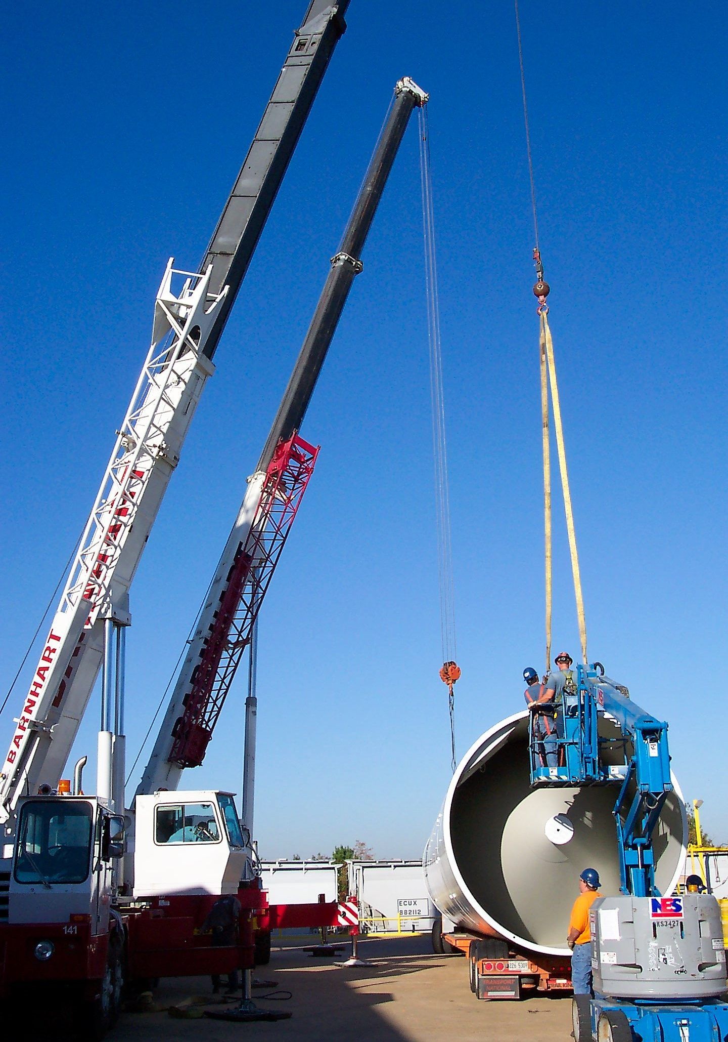 Crane lifting an industrial vessel into place at a plant site